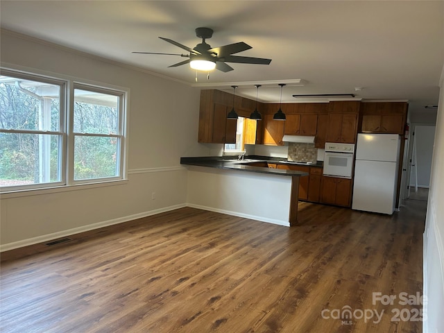 kitchen with white appliances, hanging light fixtures, decorative backsplash, ceiling fan, and kitchen peninsula