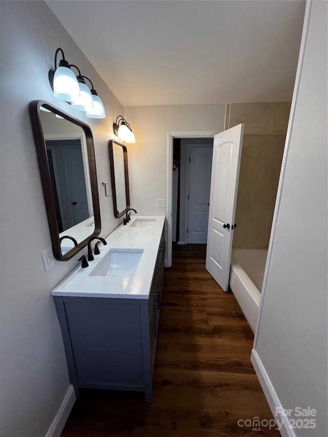 bathroom with a bath, vanity, and hardwood / wood-style flooring