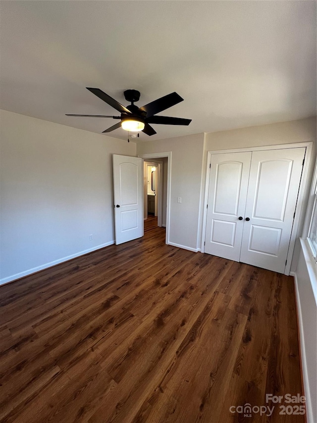 unfurnished bedroom featuring ceiling fan, dark wood-type flooring, and a closet