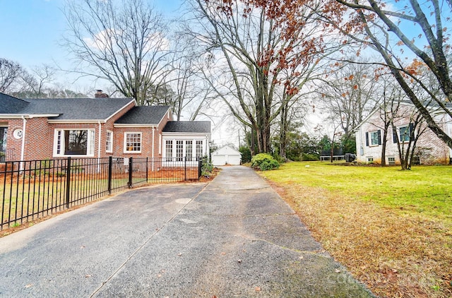 exterior space featuring a lawn, an outbuilding, and a garage