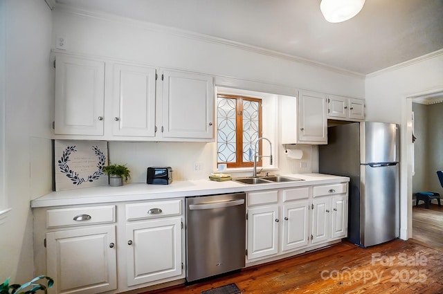 kitchen with white cabinetry, sink, stainless steel appliances, dark hardwood / wood-style flooring, and ornamental molding