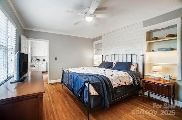 bedroom featuring wood-type flooring, ceiling fan, and crown molding