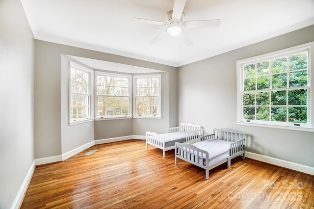 living area featuring light hardwood / wood-style floors and ceiling fan