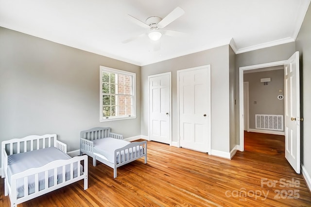 bedroom featuring hardwood / wood-style floors, ceiling fan, and ornamental molding