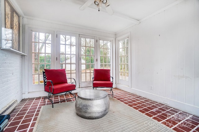 sunroom featuring a baseboard radiator, ceiling fan, and a healthy amount of sunlight