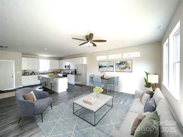 living room with ceiling fan and dark wood-type flooring