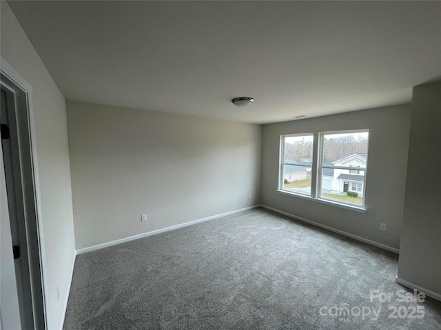 carpeted empty room with baseboards