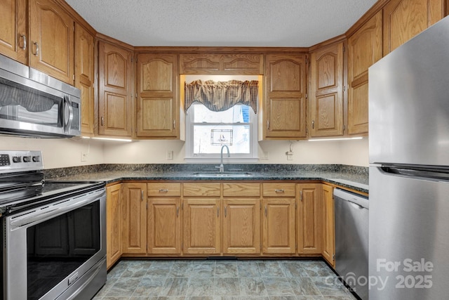 kitchen featuring sink, stainless steel appliances, and a textured ceiling