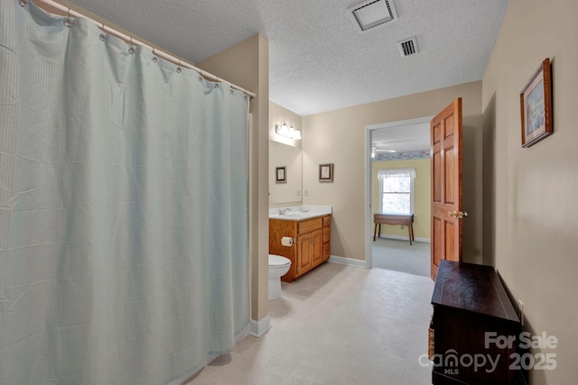 bathroom featuring a textured ceiling, vanity, and toilet