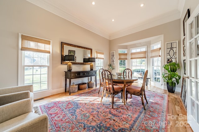 dining area featuring a healthy amount of sunlight, crown molding, and light hardwood / wood-style floors