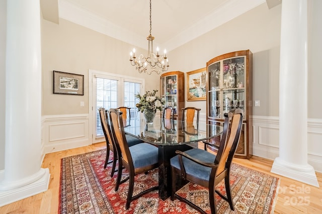 dining room featuring a chandelier, light hardwood / wood-style flooring, and decorative columns