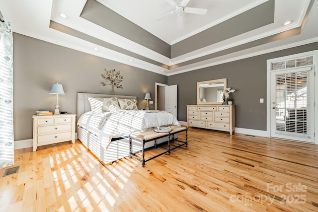 bedroom with a tray ceiling, ceiling fan, and light hardwood / wood-style floors