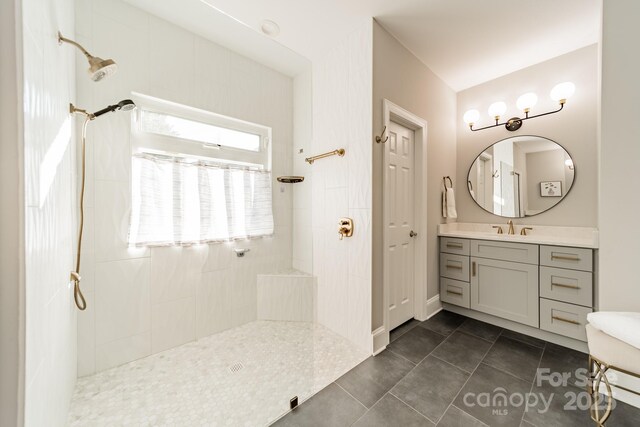 bathroom featuring a tile shower, vanity, and tile patterned floors