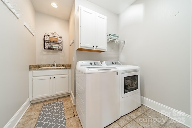 laundry room with washer and clothes dryer, cabinets, and sink