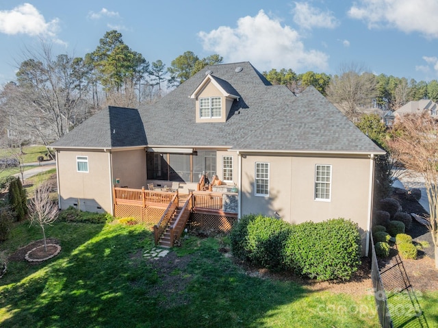 back of property with a deck and a lawn