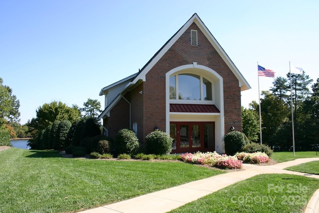 4150 Summit Ridge Ln, Denver, NC 28037 - english style home with french doors, a front yard, brick siding, and a standing seam roof