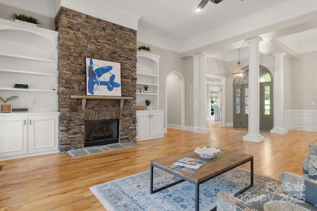 4150 Summit Ridge Ln, Denver, NC 28037 - living room featuring light wood-style floors, ornate columns, built in shelves, a stone fireplace, and ornamental molding