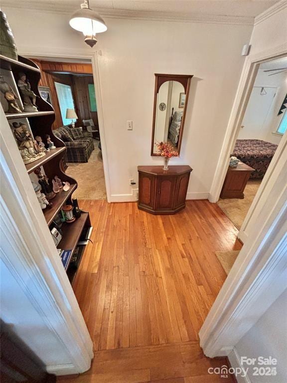 hall with crown molding and light wood-type flooring