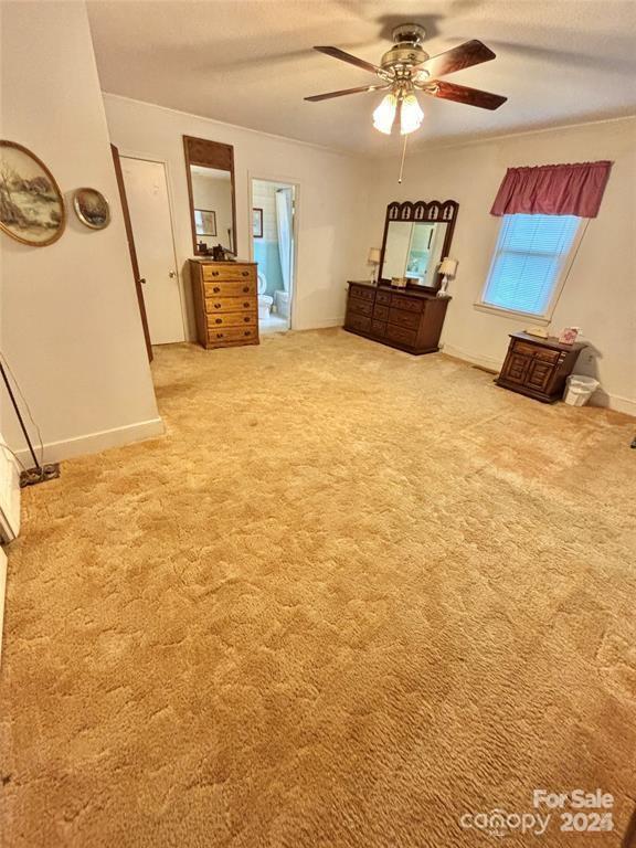 unfurnished bedroom with carpet, a textured ceiling, and ceiling fan