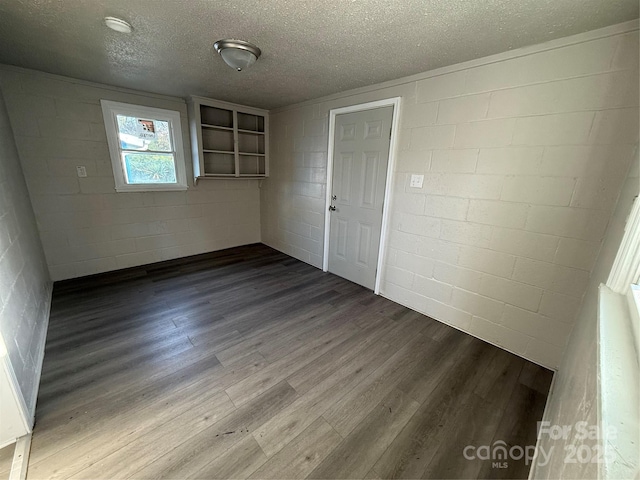 spare room featuring wood-type flooring and a textured ceiling