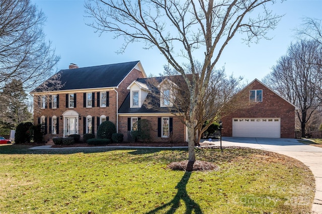 colonial home featuring a garage and a front yard