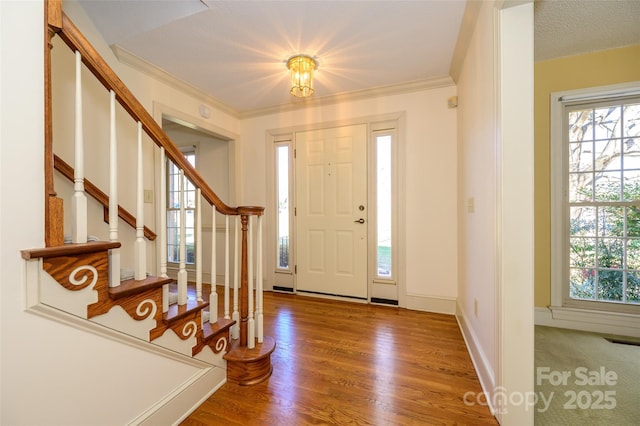 entrance foyer with crown molding, hardwood / wood-style floors, and a textured ceiling