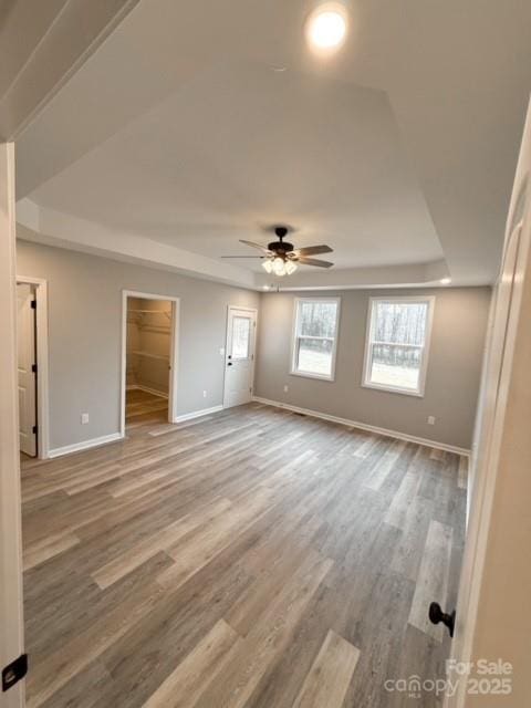 spare room with a tray ceiling, ceiling fan, and hardwood / wood-style flooring