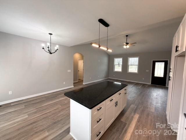 kitchen with white cabinets, decorative light fixtures, ceiling fan with notable chandelier, and dark wood-type flooring