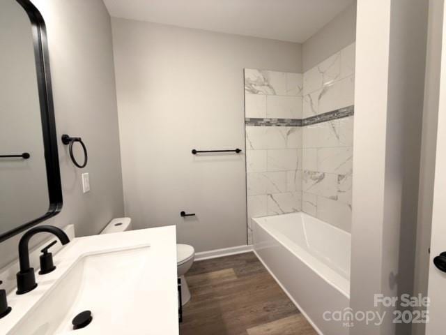 full bathroom featuring vanity, toilet, wood-type flooring, and tiled shower / bath