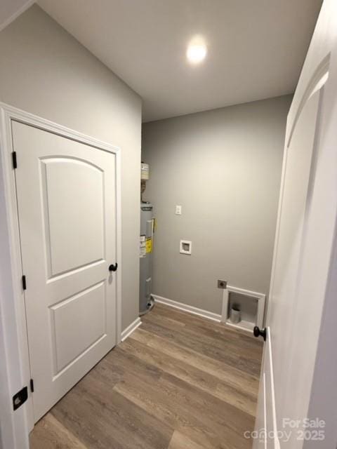 washroom featuring light hardwood / wood-style floors, electric water heater, and hookup for a washing machine