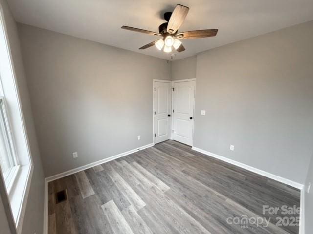 unfurnished room with ceiling fan and dark wood-type flooring