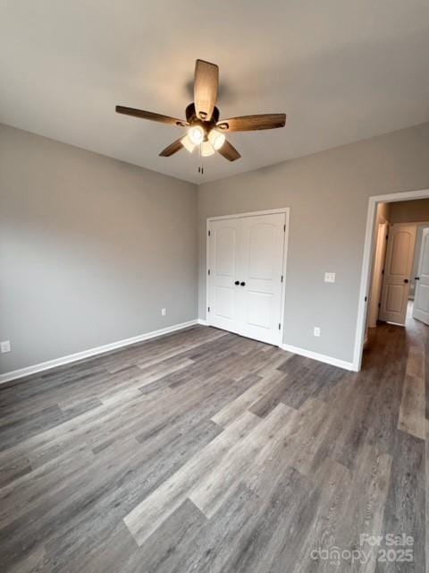 unfurnished bedroom with ceiling fan, dark hardwood / wood-style flooring, and a closet