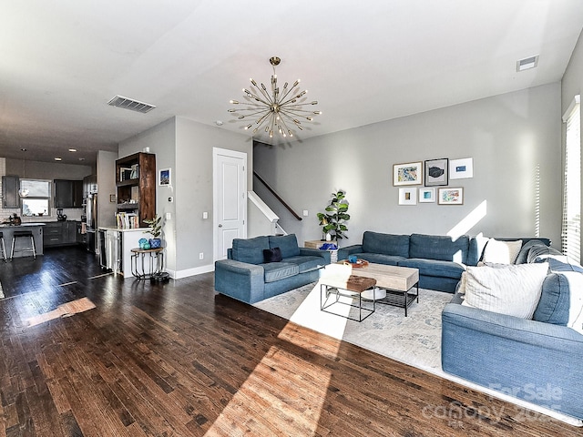 living room featuring dark wood-type flooring and a chandelier