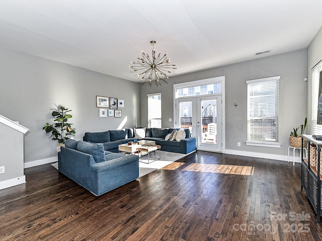 living room with french doors, dark hardwood / wood-style floors, and a notable chandelier