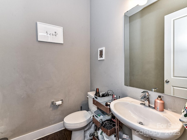 bathroom with hardwood / wood-style flooring, toilet, and sink