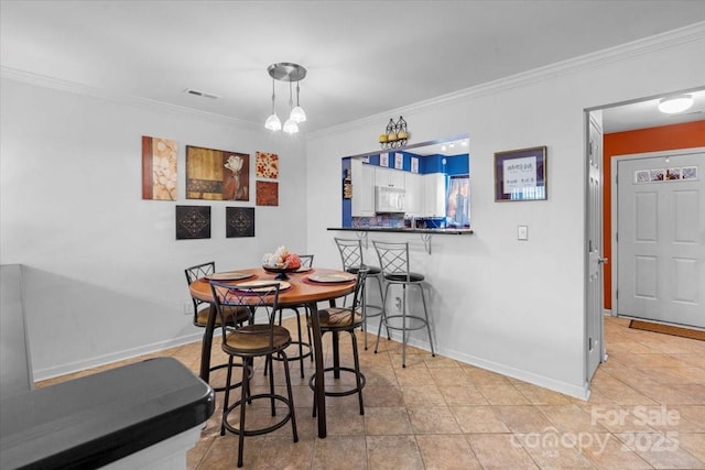 dining area featuring light tile patterned floors and ornamental molding