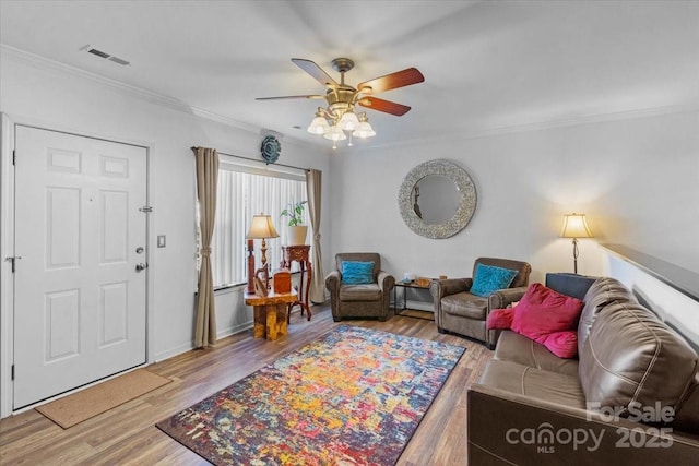 living room with crown molding, ceiling fan, and light hardwood / wood-style floors