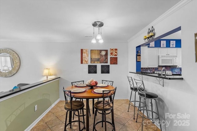 tiled dining area featuring a chandelier and crown molding