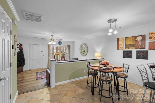 dining area featuring ceiling fan, ornamental molding, and light tile patterned floors