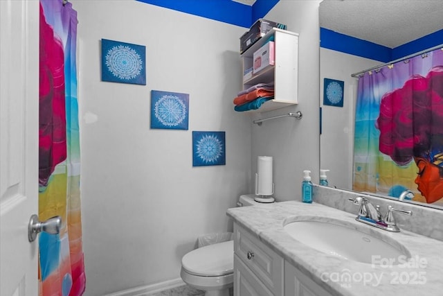 bathroom featuring vanity, a textured ceiling, and toilet