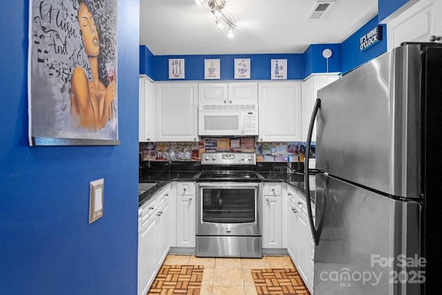 kitchen with decorative backsplash, light tile patterned flooring, white cabinetry, and stainless steel appliances