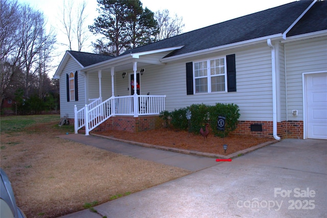 ranch-style house featuring covered porch and a garage