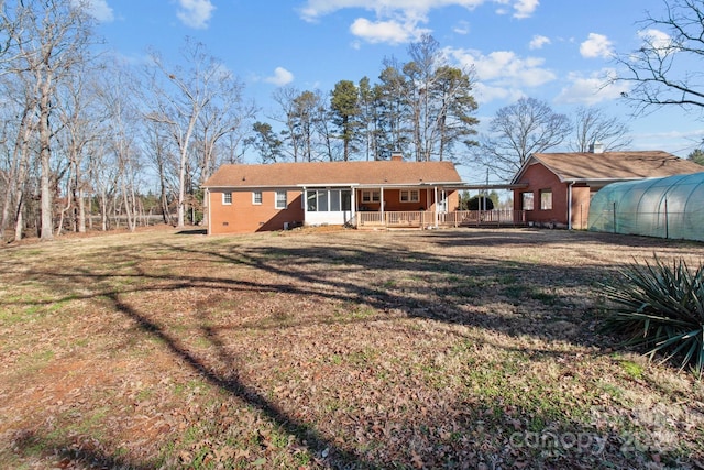 rear view of house with a yard and a sunroom