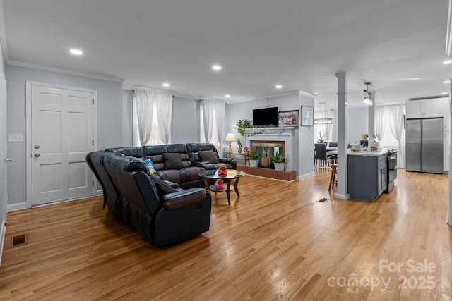 living room with light wood-type flooring and crown molding