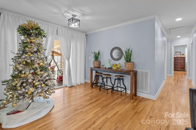 interior space with light hardwood / wood-style floors and crown molding