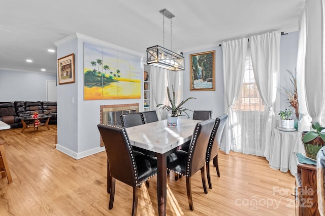 dining area with an inviting chandelier, light hardwood / wood-style flooring, and crown molding