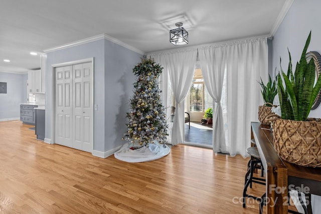 entryway with light wood-type flooring and crown molding