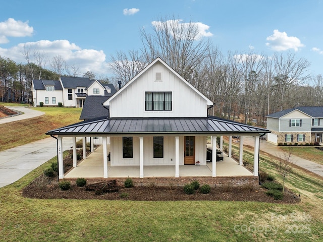 back of property featuring covered porch and a yard