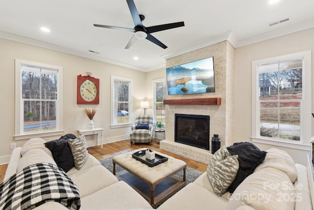 living room featuring crown molding, a fireplace, and hardwood / wood-style flooring