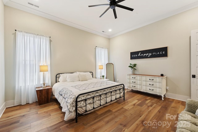 bedroom with ceiling fan, hardwood / wood-style flooring, and crown molding